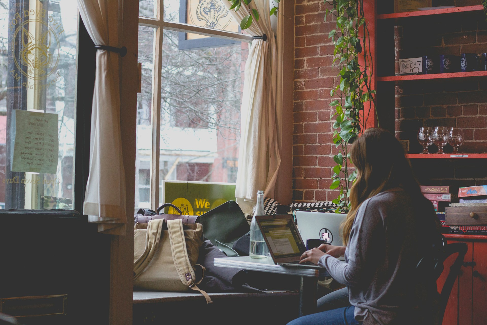 A woman writing in a cafe, by @bonniekdesign on Unsplash